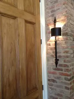 Vägglampa vid trädörr.
